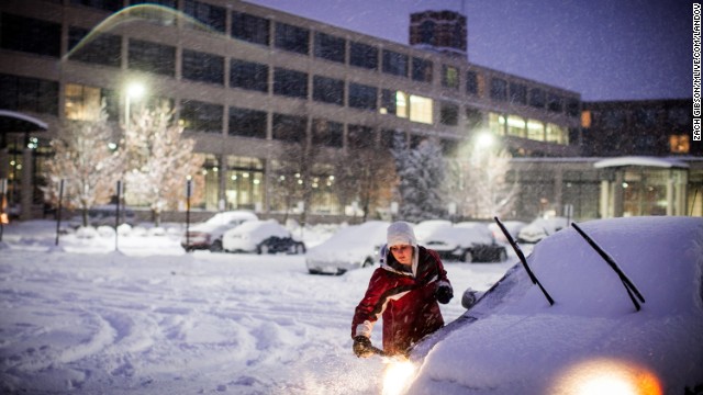 Alisha Henry scrapes snow off her car before heading home from work November 18 in Grand Rapids, Michigan.