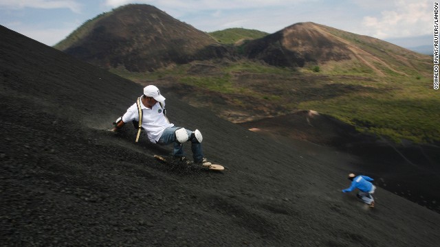 Two men coast down the Cerro Negro volcano in Leon City, Nicaragua. The Cerro Negro is one of Nicaragua's most active volcanoes, and it is a popular spot for the young sport of volcano boarding, or volcano surfing.