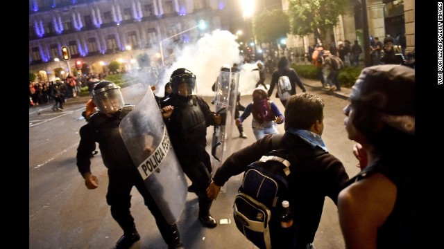 Demonstrators clash with riot police.