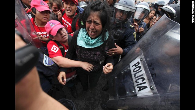 A protester cries as police attempt to detain her and human rights observers try to reach her during a march near the Mexico City airport.