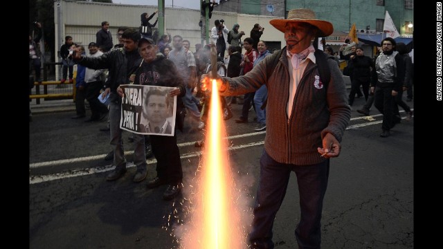 A protester lights a firework as demonstrators march November 20.