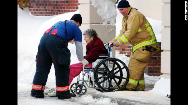 Firefighters from Cheektowaga and Depew, New York, assist an elderly patient from from Garden Gate Health Care Facility to the Appletree Mall November 20. About 180 patients from the facility were moved after officials questioned the safety of the roof under the weight of the snowfall.