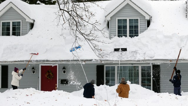 People clear snow from a house on Saturday, November 22 in Orchard Park, New York. 