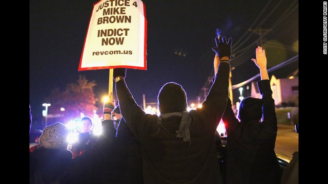 Demonstrators are confronted by police as they block a street before the grand jury announcement. 