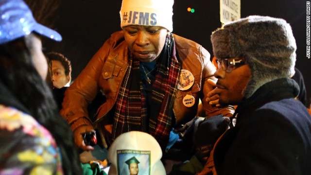 Lesley McSpadden, mother of Michael Brown, is escorted away from the Ferguson Police Department on November 24.