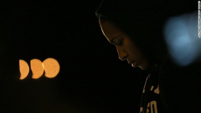 A demonstrator listens to a car radio as the grand jury's decision is delivered in front of the Ferguson Police Department.