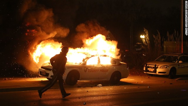A police officer runs by a burning police car on November 24.