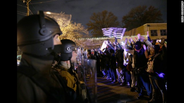 Police officers stand guard as protesters confront them on November 24.