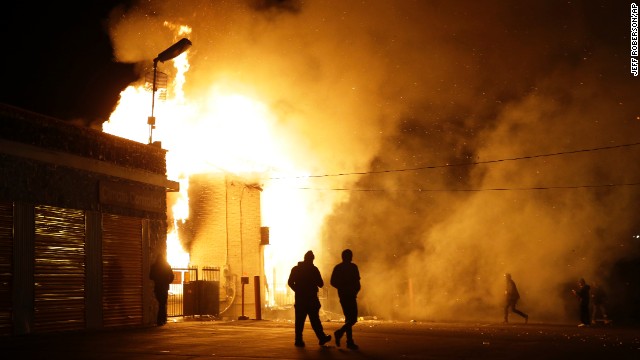 People walk away from a burning storage facility on November 24.