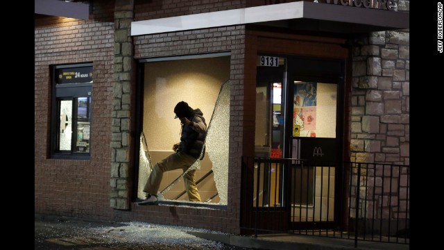 A man steps out of a vandalized store on November 24.