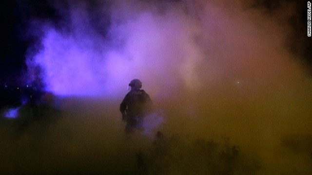 Smoke engulfs a police officer on November 25.