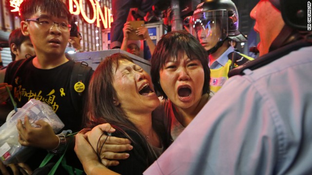 Protesters cry as police officers try to stop them from blocking the road in the Mong Kok district of Hong Kong on Wednesday, November 26. 