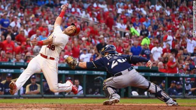 Tony Cruz of the St. Louis Cardinals avoids a tag from Milwaukee catcher Jonathan Lucroy and scores a run Saturday, August 2, in St. Louis.