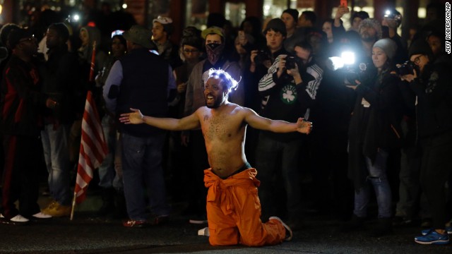 A man kneels in the middle of a street and yells at police before being arrested outside the police department in Ferguson, Missouri, on Saturday, November 29. Ferguson has struggled to return to normal since Michael Brown, an unarmed black teenager, was killed by Darren Wilson, a white police officer, on August 9. The grand jury's decision not to indict Wilson prompted new waves of protests in Ferguson and across the country.