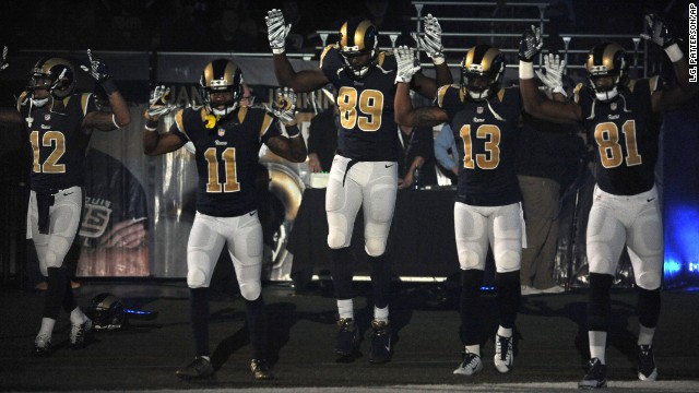 Members of the St. Louis Rams raise their arms as they walk onto the field in St. Louis before their NFL game against the Oakland Raiders on Sunday, November 30. 