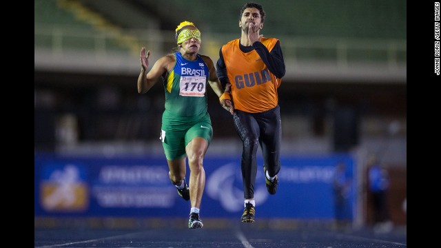 Sprinter Terezinha Guilhermina competes in the 200 meters along with her guide, Guilherme Santana, during the T11 final of the Brazilian Athletics Open Championships on Thursday, April 24. The T11 category is for athletes who are visually impaired.