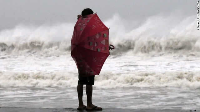 A Filipino resident watches strong waves at a coastal village on Samar island, Philippines, on Saturday, December 6. Typhoon Hagupit, whose name means "lash" in Filipino, came ashore on the island's eastern shore.