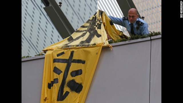 A police officer removes a protest banner from a bridge December 11.