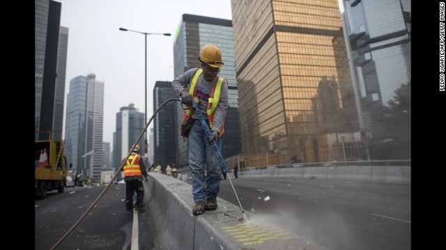 A worker cleans the street after Hong Kong police dismantled the main protest camp December 11.