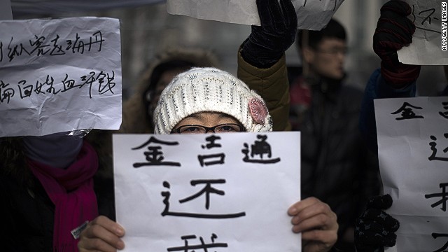 A woman holds up a sign reading 