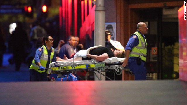 An injured hostage is wheeled to an ambulance after shots were fired during the raid on the cafe.