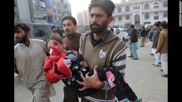 An injured girl gets rushed to a hospital in Peshawar.