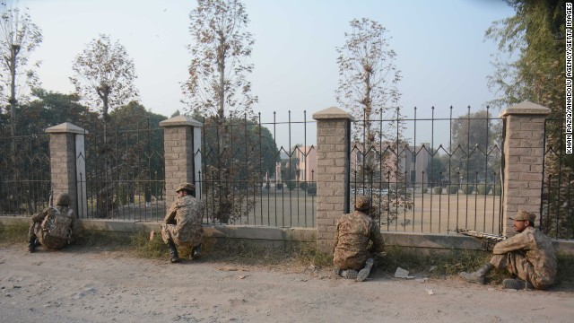 Pakistani soldiers position themselves at a fence near the besieged school.