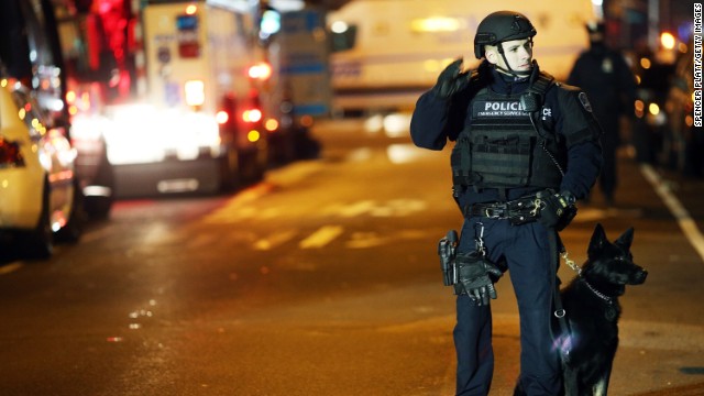 An officer with a police dog monitors the scene on the evening of December 20. 