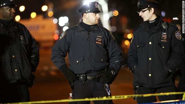 Police officers gather near the scene of the shooting. U.S. Attorney General Eric Holder called the attack "an unspeakable act of barbarism." 