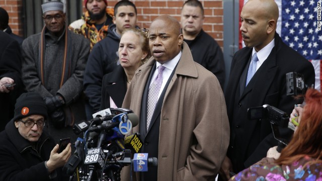Brooklyn Borough President Eric Adams, third from right, speaks on December 21 while Manhattan Borough President Gale Brewer, fourth from right, and Bronx Borough President Ruben Diaz, right, listen during a news conference at an impromptu memorial near the site where the officers were shot. 