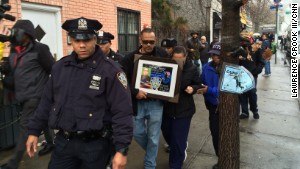 Visitors pay respects to two slain police officers this week at a memorial in New York\'s Bedford-Stuyvesant neighborhood.