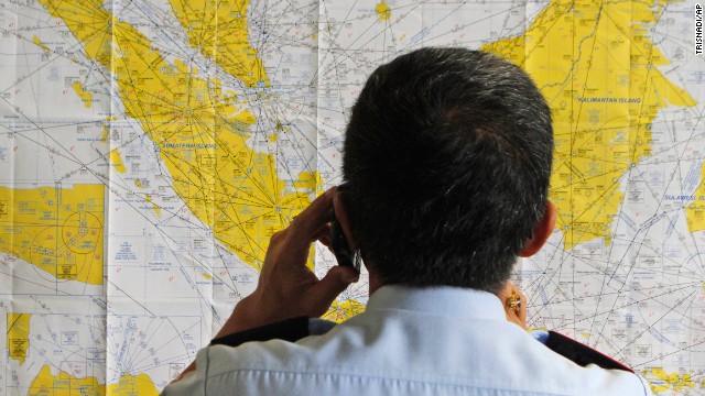 An airport official checks a map of Indonesia at the crisis center for the missing flight, set up by local authorities at Juanda International Airport.