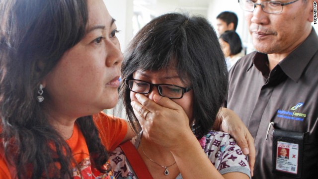 A relative weeps as she waits for the latest news on the missing jetliner.