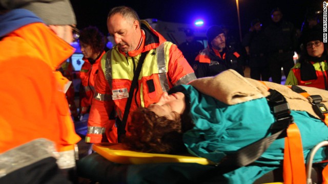 A rescued passenger is carried by paramedics.