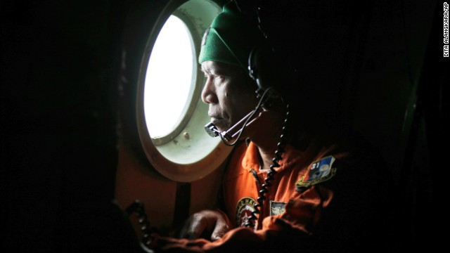 An Indonesian military airman looks out of the window of an airplane during the search for missing AirAsia Flight QZ8501 over the waters of Karimata Strait in Indonesia on Monday, December 29. The passenger jet, carrying 162 people, lost contact with Indonesian air traffic control early Sunday, marking the second major missing plane crisis in Southeast Asia in less than a year.