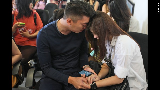 Relatives comfort each other at the airport on December 28. The search operation for the missing flight was been halted for the night.