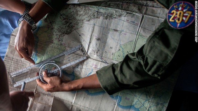 Indonesian army personnel read a map during a search operation over the waters of the Java Sea on December 29.