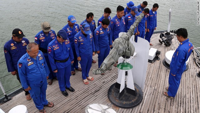 Members of Indonesia's Marine Police pray before a search operation for the missing jet on December 29.