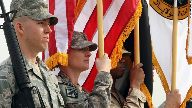 U.S. soldiers hold the U.S. and Iraqi flags during a symbolic flag-lowering ceremony marking the end of the U.S. mission in Iraq at a military base West of Baghdad on December 15, 2011. 