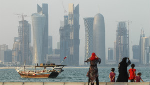 Women and children enjoy the waterfront along the Persian Gulf across from new, budding financial district skyscrapers as a traditional Arab ship passes by on October 24, 2011 in Doha, Qatar. 