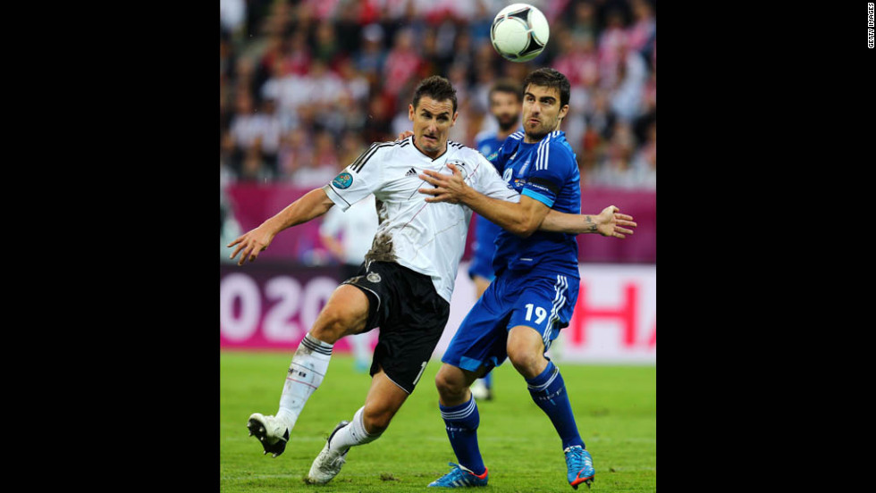 Miroslav Klose of Germany and Sokratis Papastathopoulos of Greece fight for the ball.