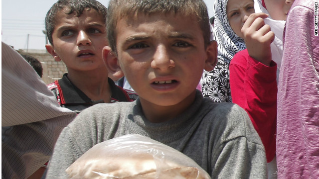 A Syrian boy carries bags of bread after as people queue up outside a bakery in the northern town of Aldana near Syria&#39;s second largest city Aleppo, on July 31, 2012. 