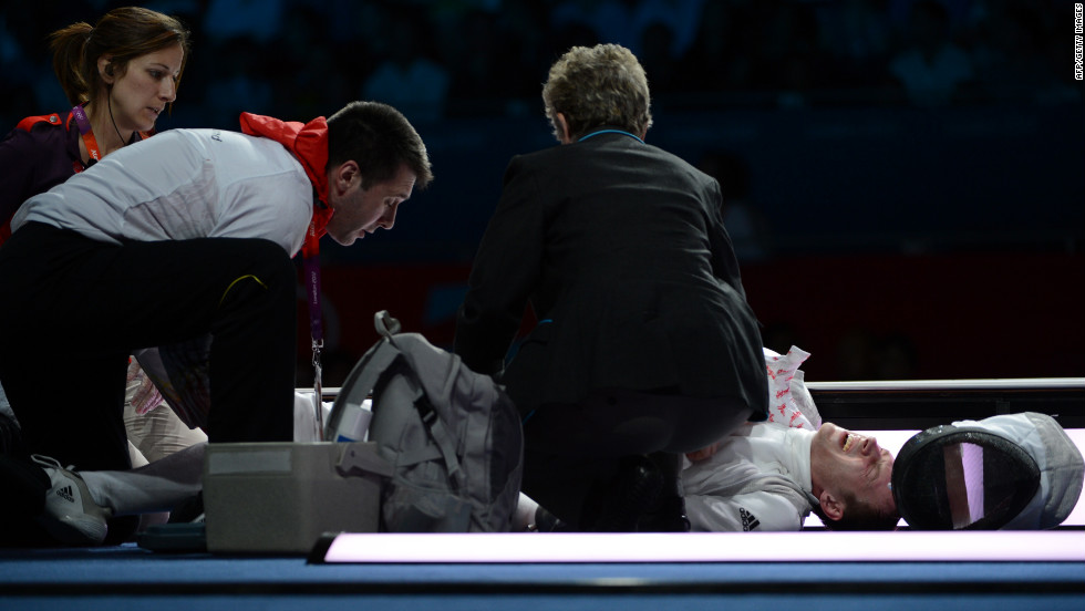 Germany's Sebastian Bachmann is treated by medical personnel after being injured during his bout with U.S. fencer Gerek Meinhardt during the men's foil team medal bronze match.