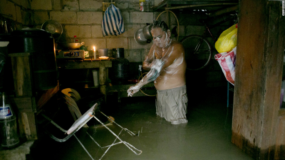 Antonio Navarro Sambiilay bathes inside his flooded home in Bulacan, Philippines.