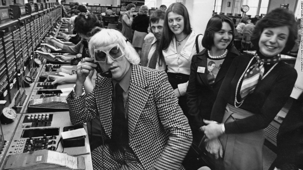 Savile calls from the Wren House International Telephone Exchange in London in 1975 as part of a "Fun And Happiness Weekend," organized by the National Association of Youth Clubs.
