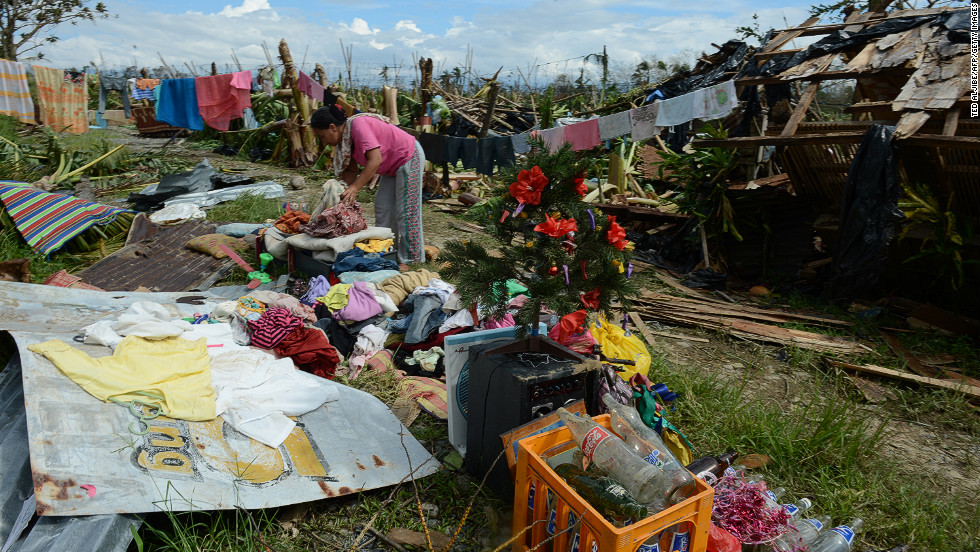 A woman sorts out clothes and belongings in front of her damaged house in Montevista on December 5.