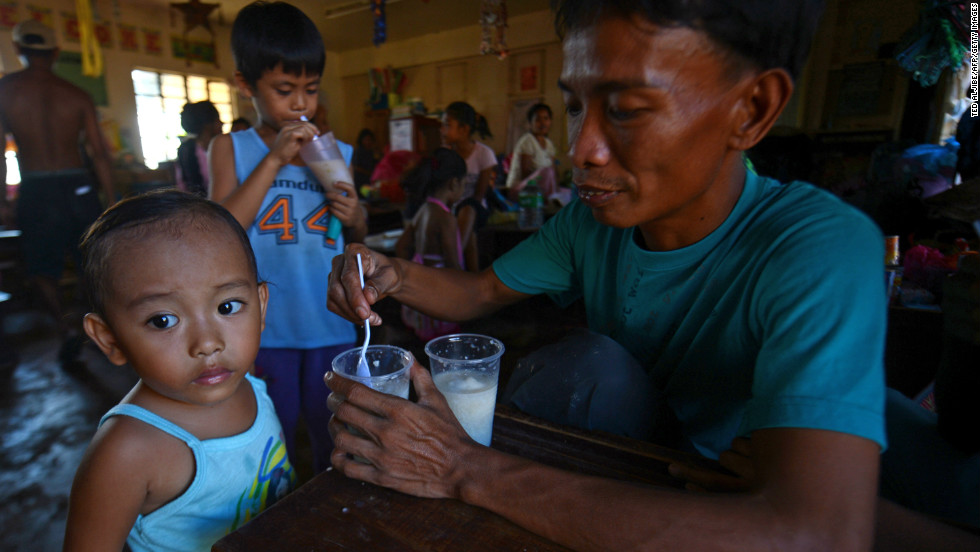 A man feeds his children at an evacuation center for victims of Typhoon Bopha in the town of Maparat in Compostela Valley province on December 8.