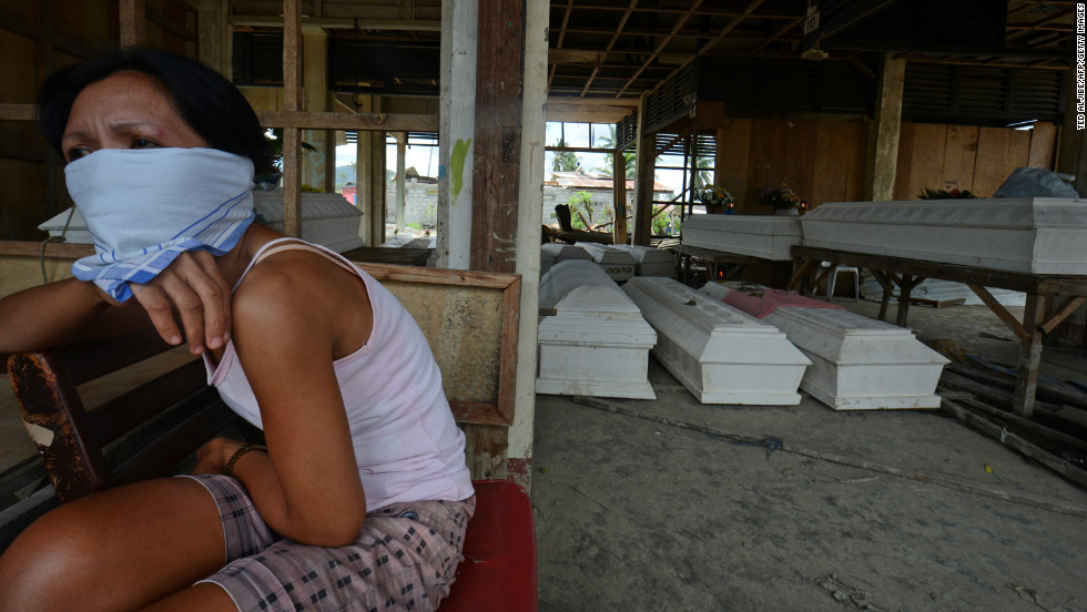 A resident sits next to coffins at the old market in New Bataan on December 8.