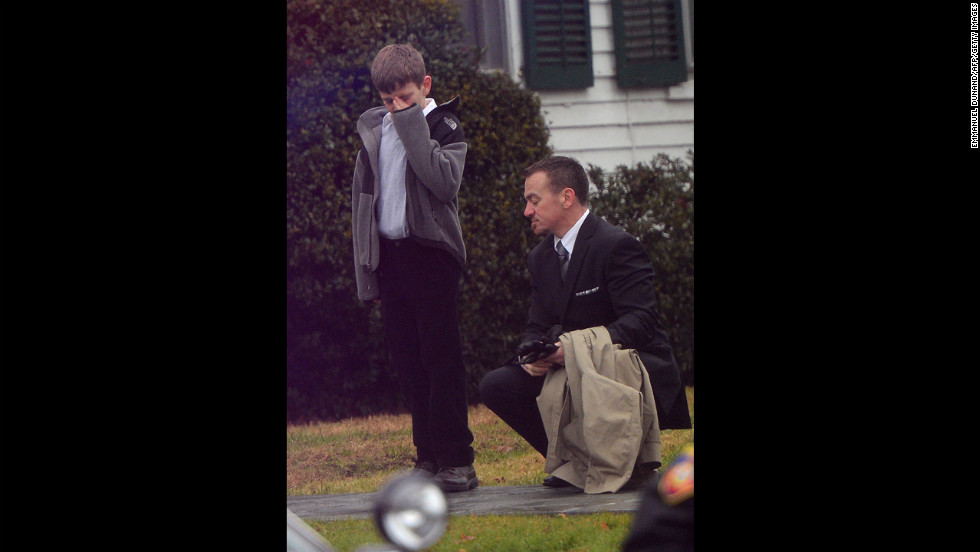 A man comforts a young mourner at Honan Funeral Home while attending the funeral for Jack Pinto, 6, on December 17.
