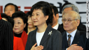 South Korea&#39;s president-elect Park Geun-Hye (L) from the ruling New Frontier Party salutes the national flag during a ceremony to disband her election camp at the party&#39;s headquarters in Seoul on December 20, 2012. South Korea elected its first woman president on December 19 with voters handing a slim but historic victory to conservative candidate Park Geun-Hye, daughter of the country&#39;s former military ruler. 